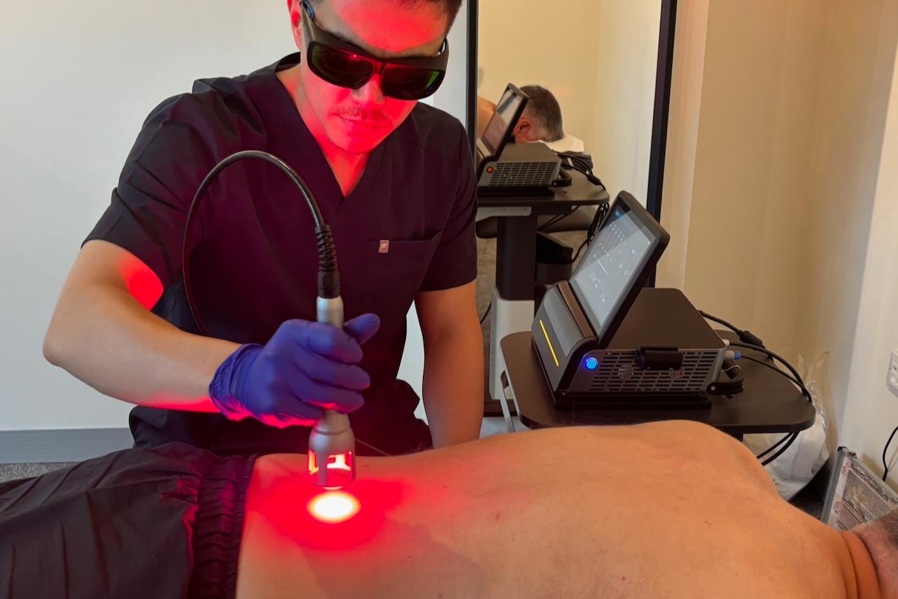 Clinician applying laser treatment to back
